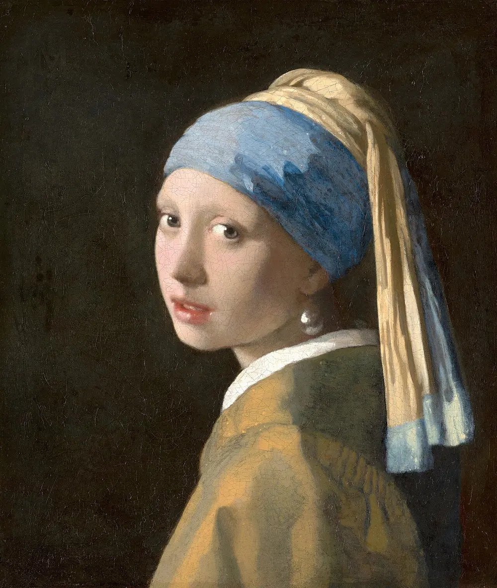 A girl against a black background looks back over her shoulder at the viewer with parted lips, wearing a blue and yellow turban and a large shining pearl drop in her ear.