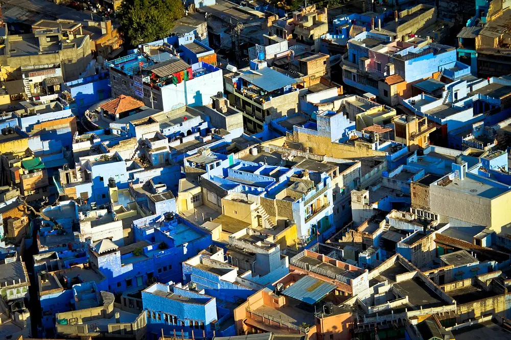Rooftops of a crowded old town, with many houses painted bright blue.