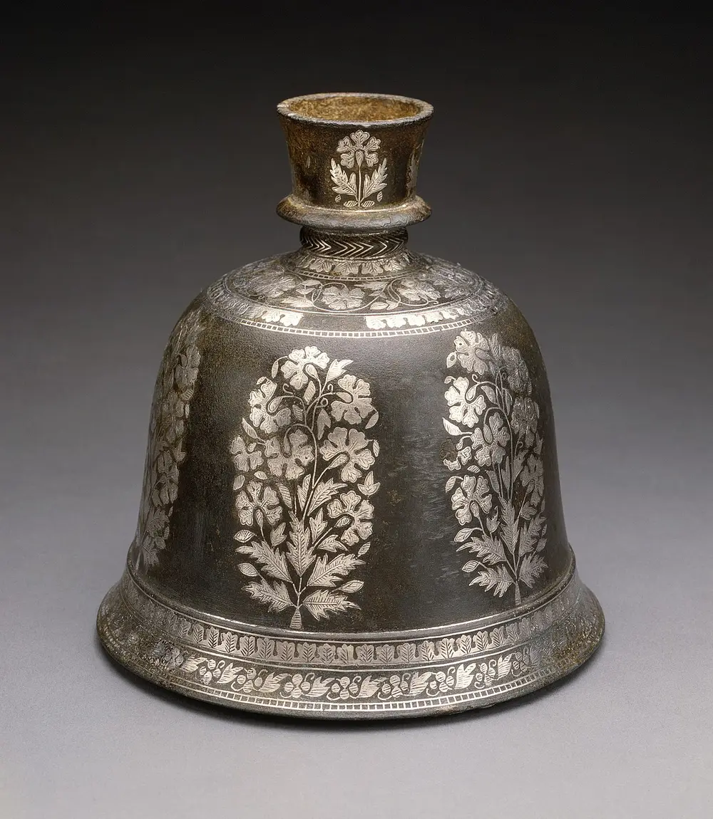 A bell-shaped black metal hookah base inlaid with large silver flowering plants and silver bands of tiny patterns.