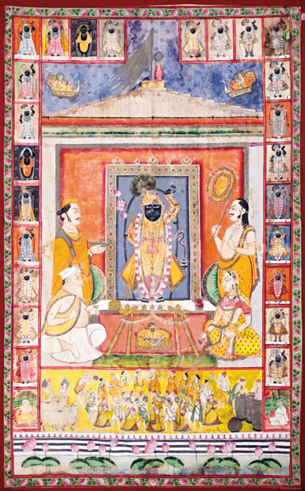 A painted cloth with a dark image of Shrinathji in a shrine at the centre, priests on each side, a band of worshippers below, and small repeated images of the god around the border.