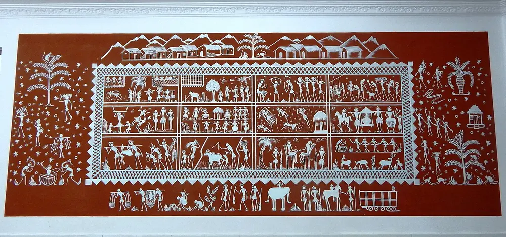 A long red wall panel painted in white, with a framed box in the middle filled with rows of small figures, animals and houses, and more figures and trees outside the frame.