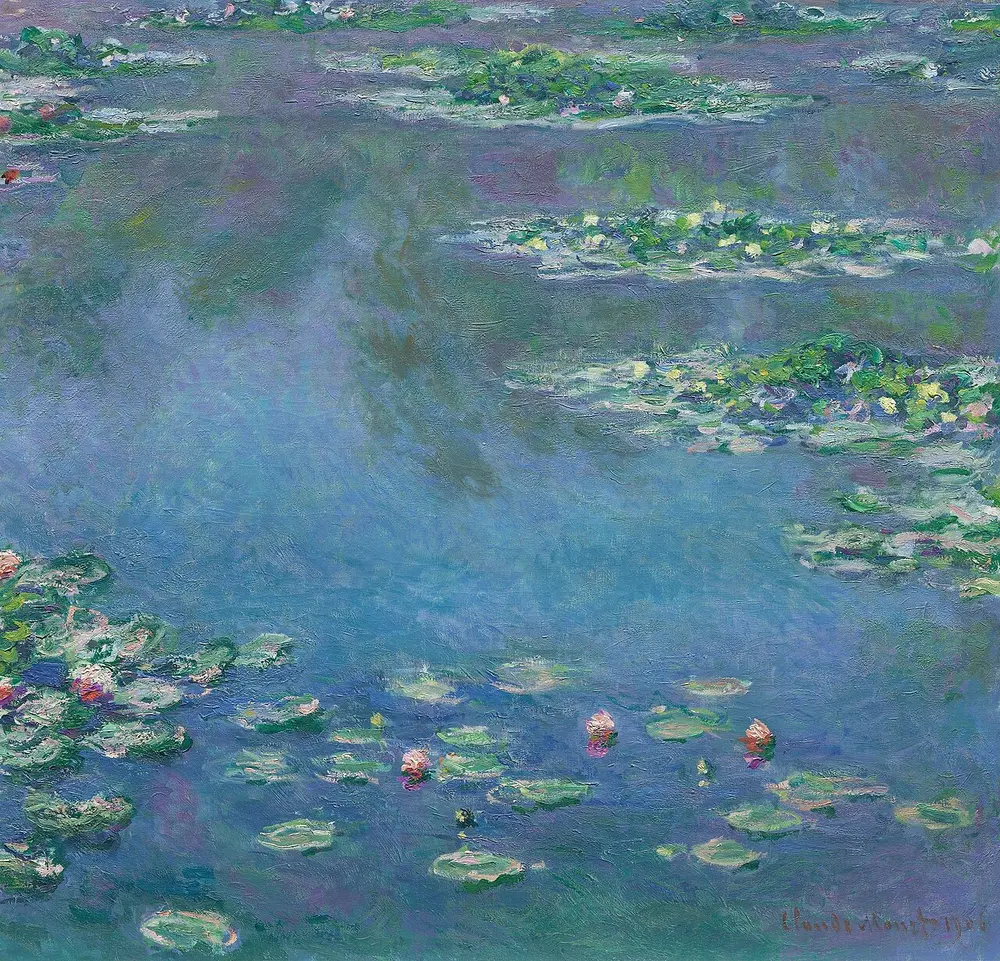 A close view of a pond surface in soft blues and violets, with floating green lily pads and small pink and white water lily flowers and the reflection of the sky.