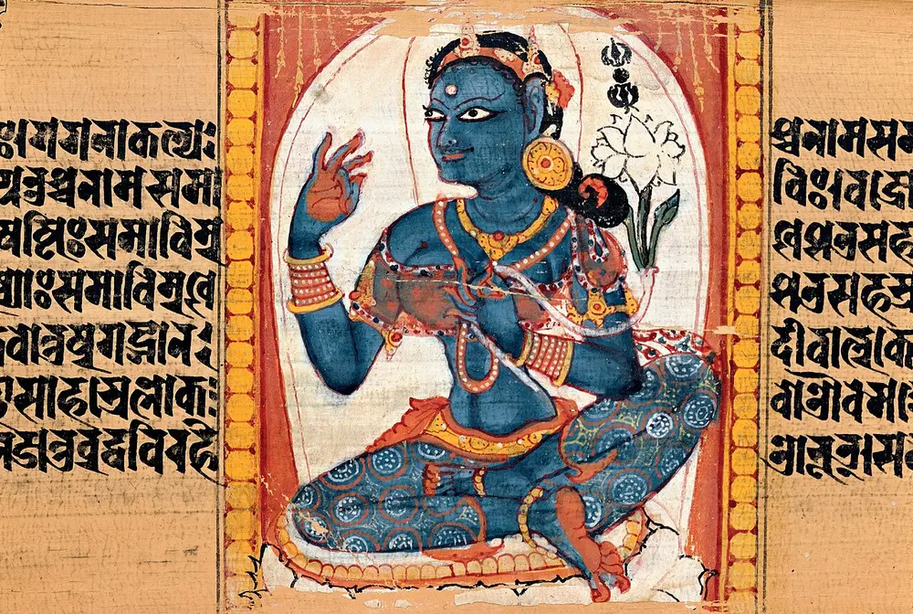 A palm-leaf page with lines of black script on both sides of a small painted panel, in which a blue goddess sits cross-legged with a white lotus beside her shoulder.