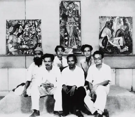 An old black and white photograph of six young men in white shirts sitting on a ledge in front of three modern paintings.
