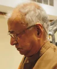 K.G. Subramanyan, an elderly man with grey hair and glasses, looking down.