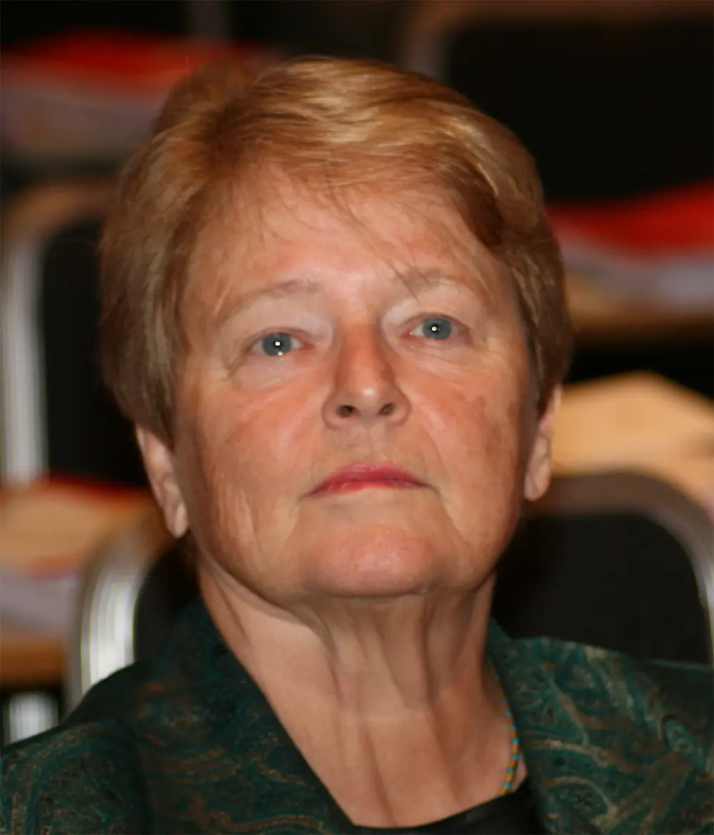 A portrait of a woman with short reddish-brown hair and a serious expression.