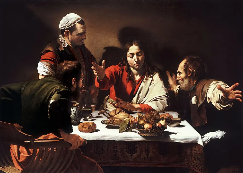 Four men around a table in a dark room. A young, beardless Christ in a red robe raises his hand in blessing, one man flings his arms wide, another grips his chair, and a basket of fruit sits on the very edge of the white tablecloth.
