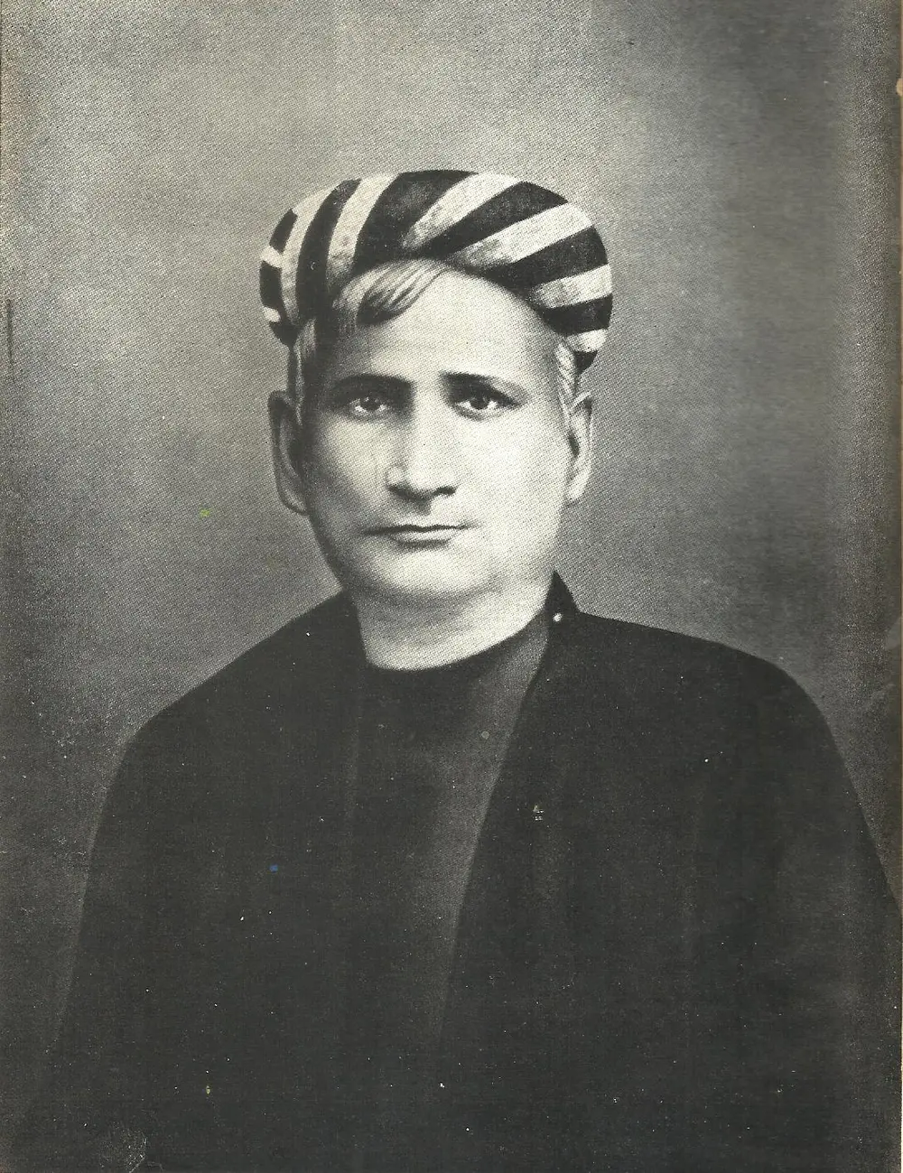 A black and white portrait of Bankim Chandra Chattopadhyay in a striped turban and a dark coat.