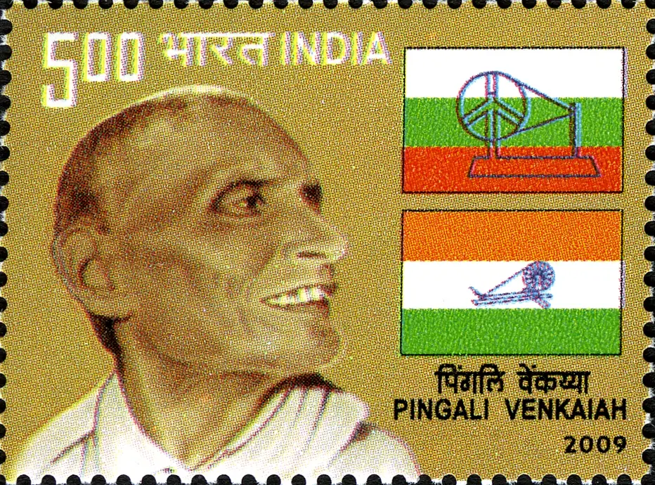 A 2009 Indian postage stamp showing Pingali Venkayya smiling, beside two early flags with a spinning wheel: one white, green and red, the other saffron, white and green.
