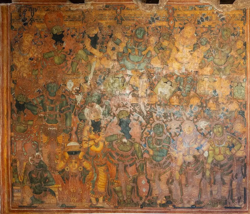 A crowded wall painting in deep orange, yellow and green, packed with richly dressed and crowned figures, some with green faces and black beards, around a fire.