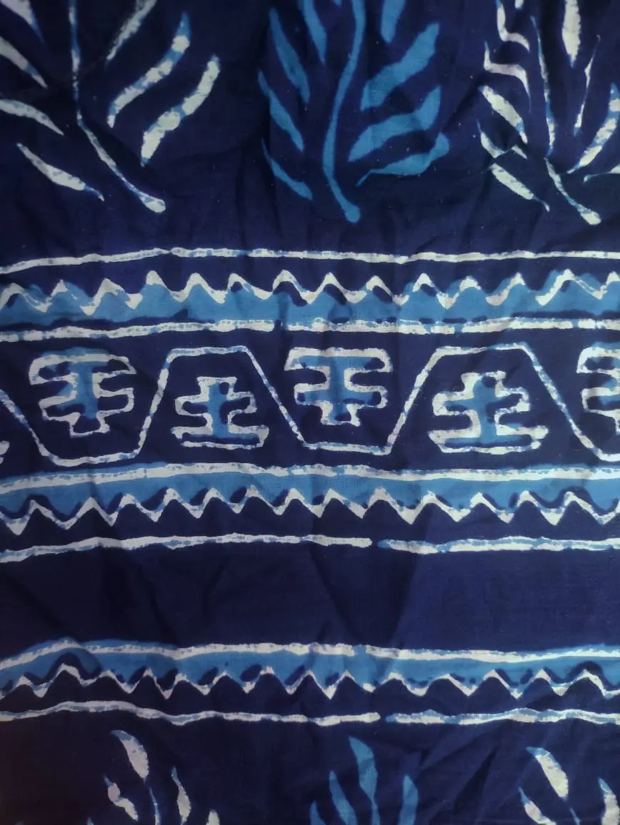 Indigo blue cotton with pale blue and white leaf shapes and a border of zigzags and boxes, the shapes edged with fine white lines.