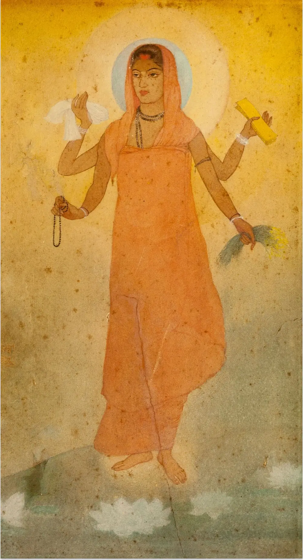 A soft watercolour of a young woman in a saffron robe standing on a misty background, with a halo, four arms holding a book, sheaves of rice, a white cloth and a rosary, and white lotuses at her feet.