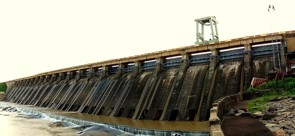 A long concrete dam with many sluice gates, stretching away into the distance.